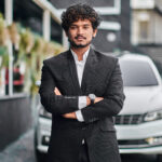 indian businessman in the background of his car